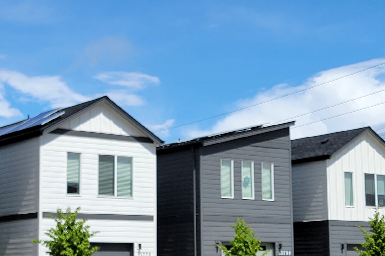 A row of newly built affordable homes at NE 20th Circle under a blue sky