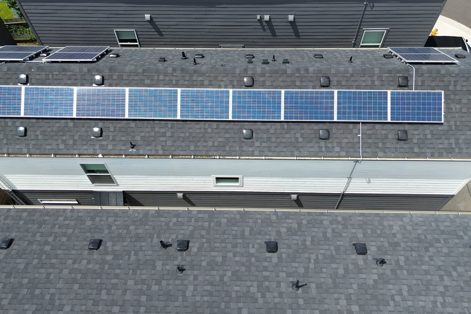 A long row of solar panels running the length of a rooftop