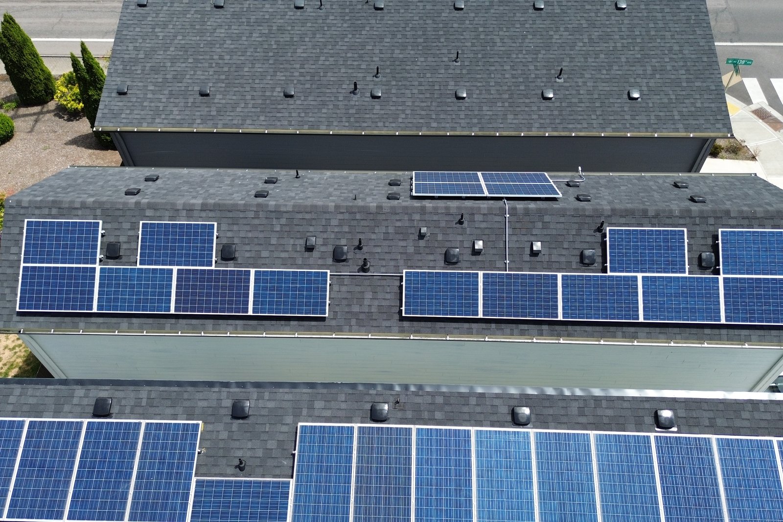 Overhead view of solar arrays covering two adjacent rooftops